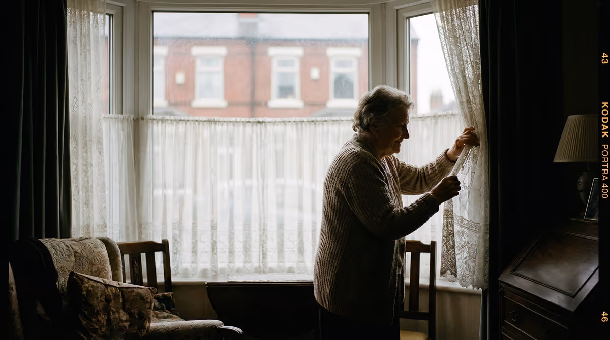 Woman by window curtains, representing comfort and safety at home